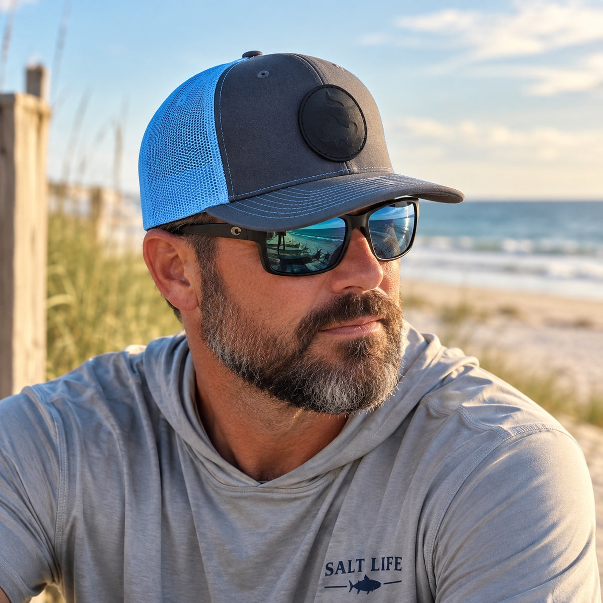 Man wearing the charcoal and blue Hammerhead Shark leather patch hat at the beach